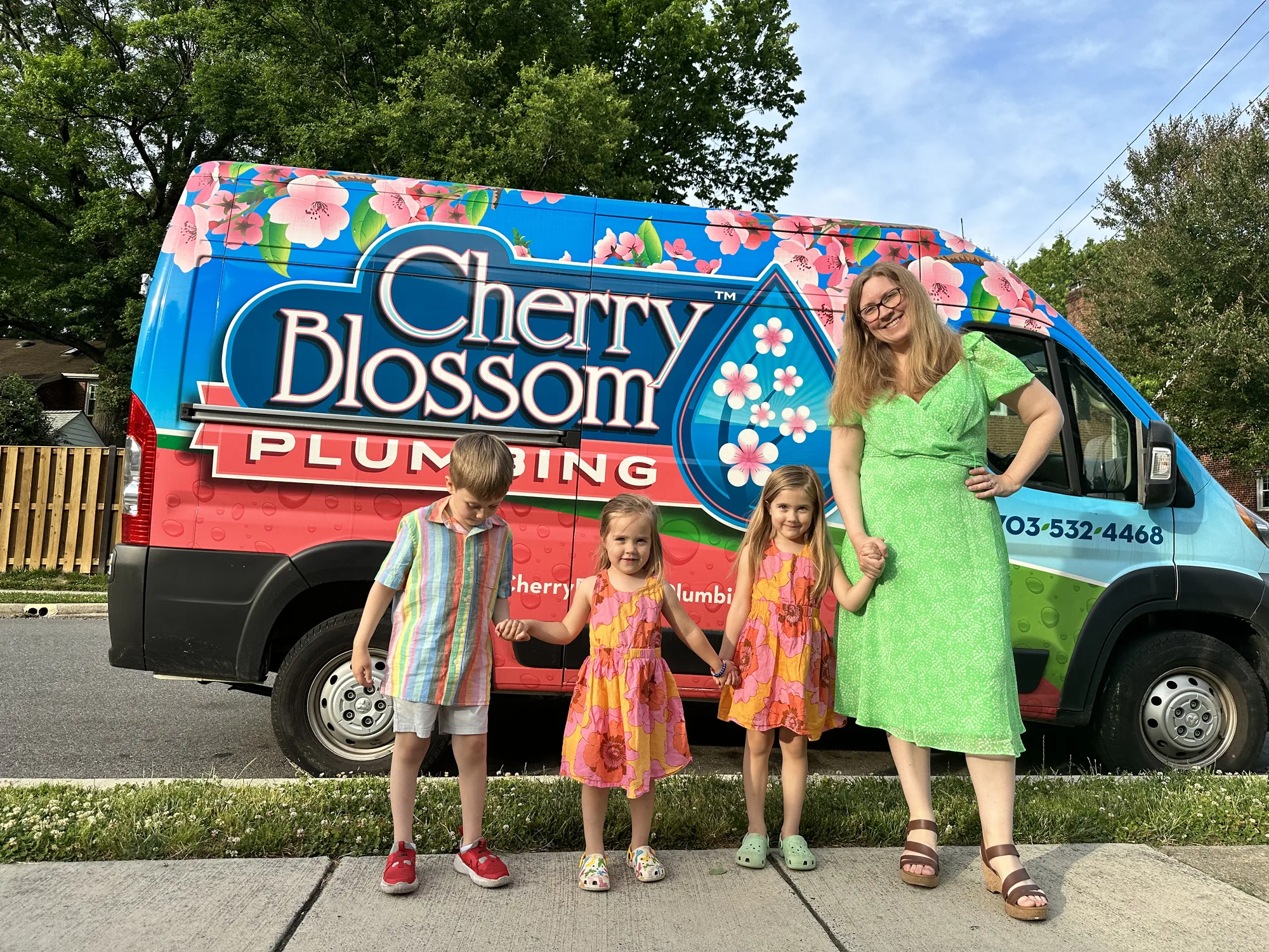 Family standing in front of a Cherry Blossom Plumbing van