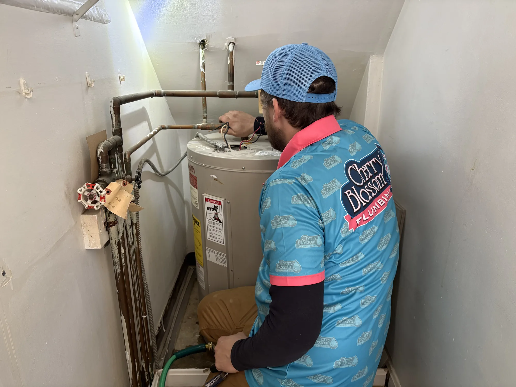 Tech Disconnecting Old Water Heater