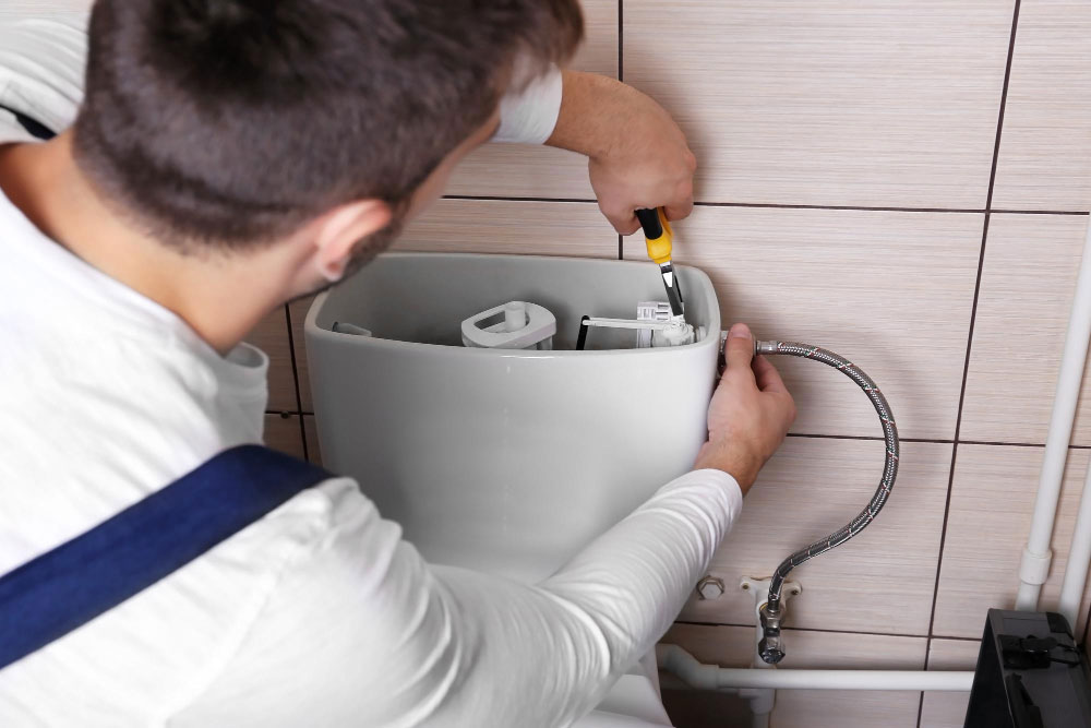 plumber repairing toilet cistern water closet
