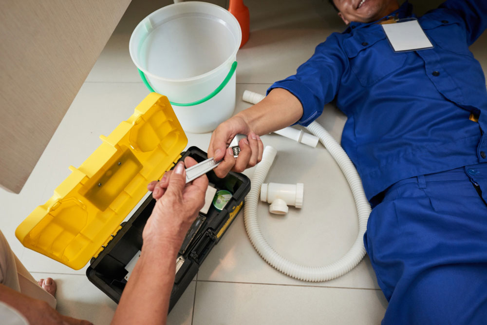 top view plumber checking kitchen fixtures