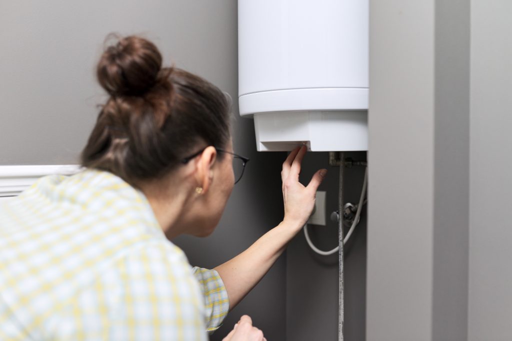 home water heater woman regulates the temperature 2023 11 27 05 10 14 utc scaled