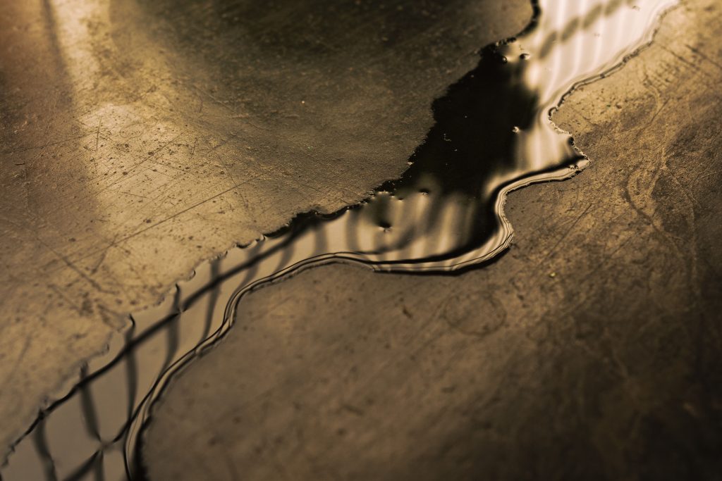 Closeup shot of a small puddle stream on a dirty floor